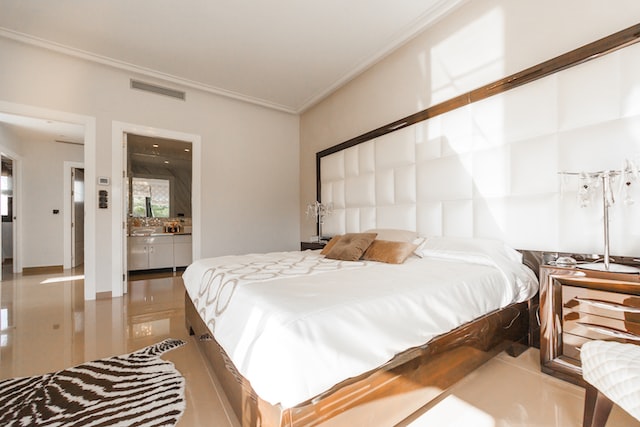  a brown wooden framed bed inside a Mediterranean-themed bedroom